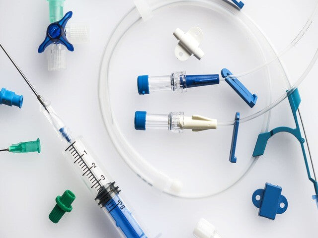Medical device components — cannulas, luer connectors and a syringe for assembly bonding.
