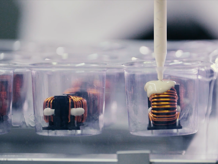 Potting compound dispensed into a housing over a wound component.